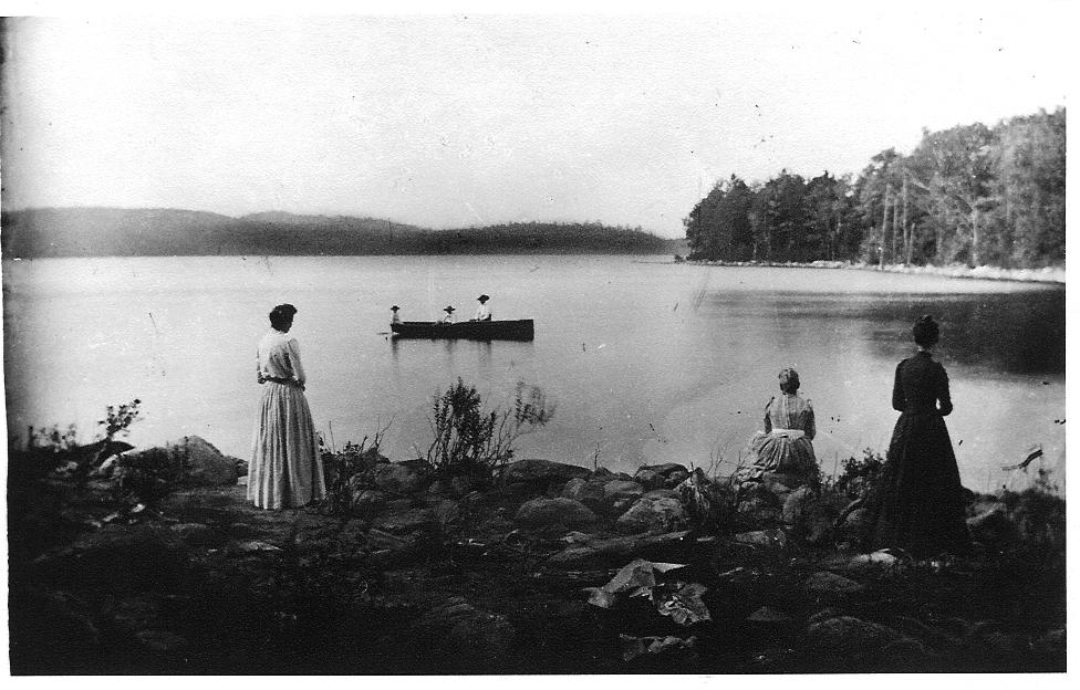 Women on West Hill shore watching men in boat